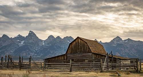 grand teton national park brown wooden barn under white sky during daytime mountain